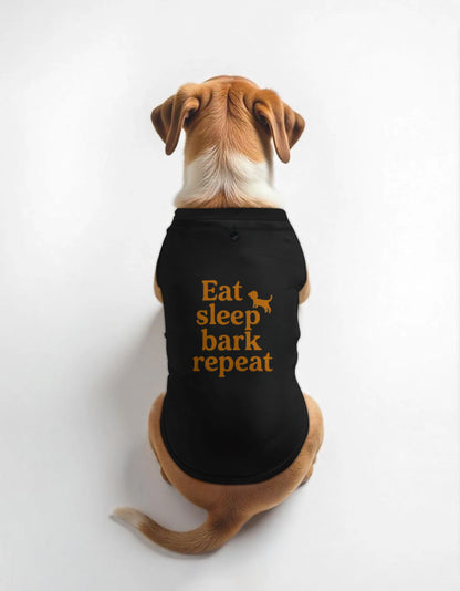 Dog wearing a black shirt with 'Eat sleep bark repeat' text on a white background