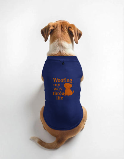 Dog wearing a blue shirt with 'Woofing my way through life' text on a white background